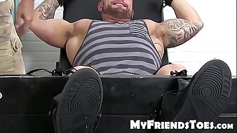 Huge muscular dude endures a feet tingling torment